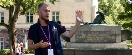 Auktorisoitu Suomenlinna-opas vetämässä opastettua kierrosta Suurella linnanpihalla, Ehrensvärdin haudan läheisyydessä.